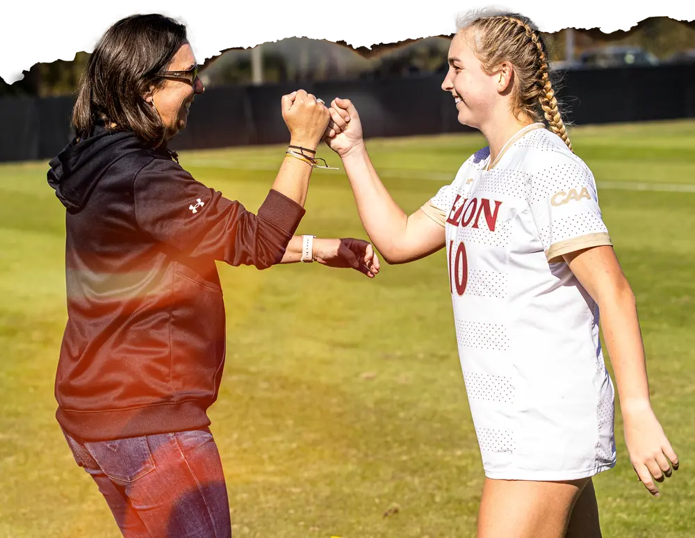 two women fist-bumping